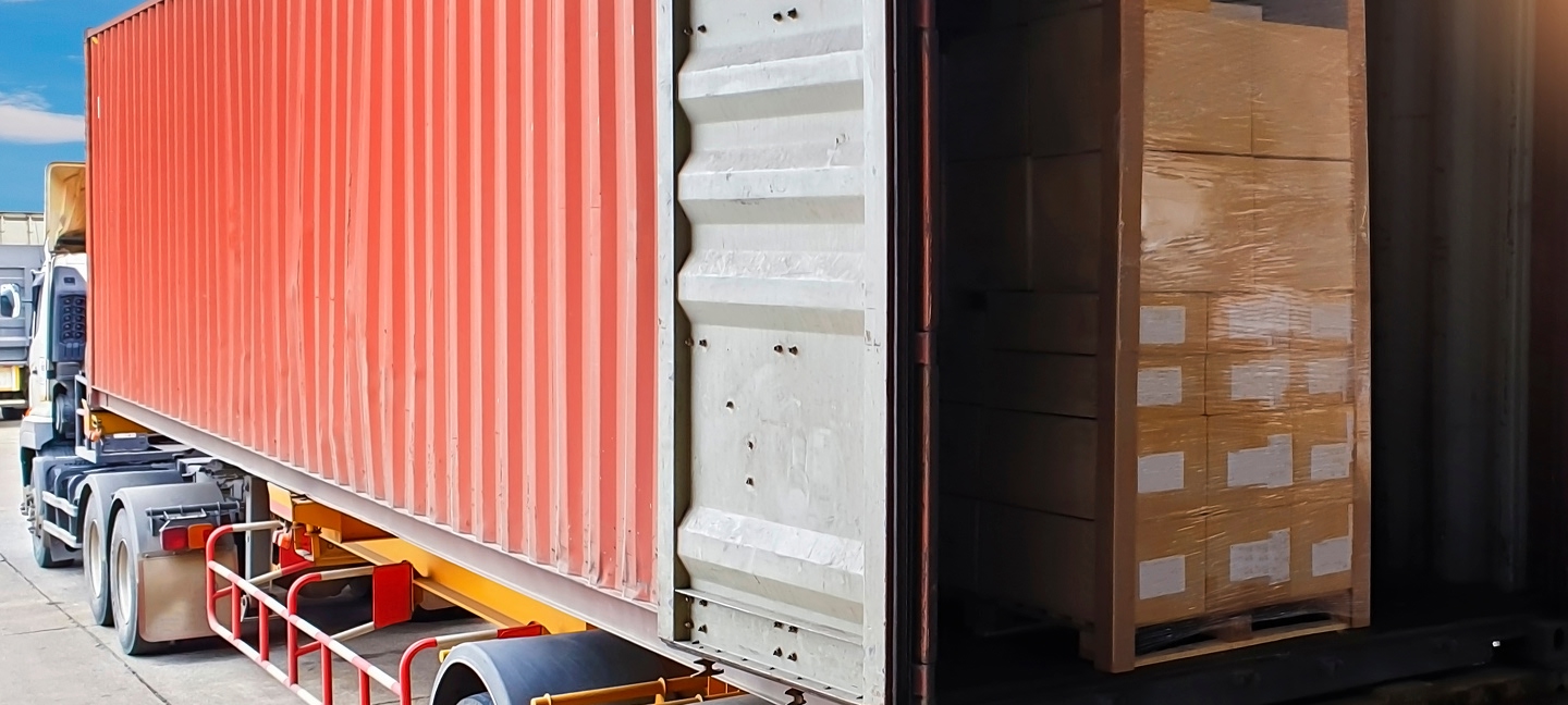 Cargo on a pallet loaded into a red semi