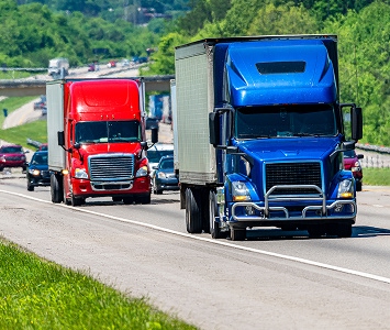 Red semi and blue semi driving on interstate